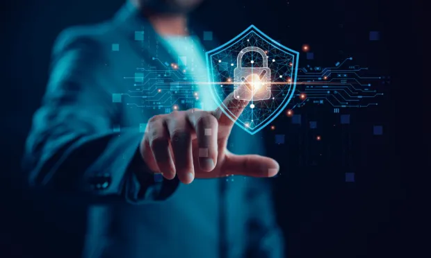 Person in front of dark background points to cyber security symbol