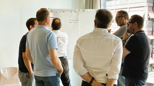 Eine Gruppe von Menschen vor einem Flipchart